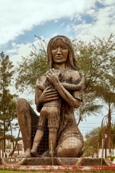 Indigenous Quechua Woman Traditional Bronze Statue of Mother Warrior feeding Son in her Breast. Monument located in a Square of a Small Village in RN 81 Argentine road to Salta Northern Region  