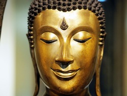 close up of a happy golden Buddha statute face