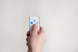 remote control in human hand, light background