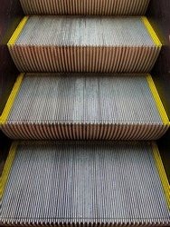 ascending metal escalator steps close up
