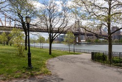 Empty Path at Queensbridge Park along the East River with the Queensboro Bridge during Spring in Long Island City Queens New York