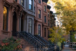 Row of Colorful Old Brownstone Homes with Stairs in Park Slope Brooklyn New York during Autumn