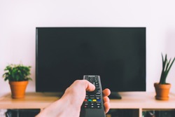 Television with remote control in hand mockup
