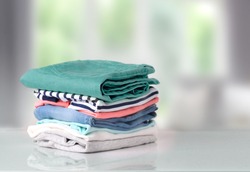 Stack of clothes on table indoor.Household concept.Fresh folded cotton clothing.