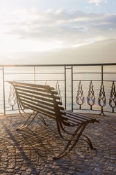 Lonely wooden bench on the observation deck in the small picturesque resort town of Bellagio Italy, on the shores of Lake Como. Soft focus.