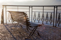 Lonely wooden bench on the observation deck in the small picturesque resort town of Bellagio Italy, on the shores of Lake Como. Soft focus.
