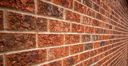 Old red bricked wall with leading lines. Perspective of leading lines in old red wall of a house.