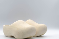 One pair of typical handmade wooden shoes on white background with free copy space, Clogs are a type of footwear made in part or completely from wood.