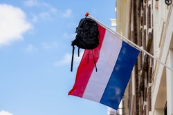 Official Netherlands flag with a school bag hanging outside the house along the street with blue sky, A tradition way in Holland when a student celebrate their graduates or Geslaagd in Dutch word.