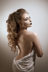 beautiful girl of European appearance in white silk fabric with bright makeup in black