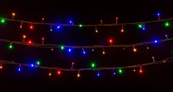 glowing colorful Christmas lights on black background