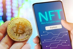 Hand holds smartphone with bitcoin cryptographic NFT blockchain marketplace,Cryptoart concept