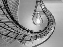 Abstract shot of a staircase leading towards a light bulb like opening