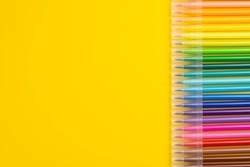 A set of colored markers.  Office and school supplies. Flat lay composition with markers and space for text on color background. Colored markers isolated on yellow background.