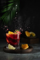 Sangria and ingredients. Refreshing sangria or punch with fruit in glasses . Sangria of red wine with ice. Traditional Spanish sangria . Drops from a squeezed orange.