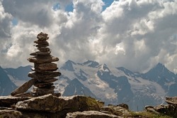 Balance of stones. Balancing stones on the top of boulder. Close up. Balance of stones on a blue sky and mountains background with a copy space. Stones balance, sustainability concept.