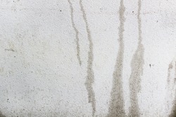 Water drips lines on grey cement house  wall