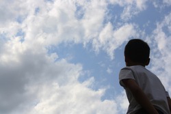 a boy looking up at the sky , a child looking up at the sky