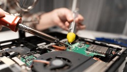 computer repairman soldering the board with a soldering iron. High quality photo
