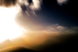 Soft, hazy, warm, expansive sky scape with bright sun behind clouds - abstract, motion-blurred background texture