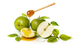 Honey dripping from wooden stick on green apples. White background. Rosh Hashanah (Jewish New Year holiday) concept.
