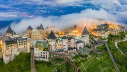 Aerial view of landscape is castles covered with fog at the top of Bana Hills, the famous tourist destination of Da Nang, Vietnam. Near Golden bridge. Panorama French village