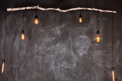 Chalkboard black background texture compose wtih open light bulb and wooden stick. Copy space