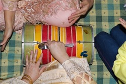 Top view shot of a ladies playing with double headed indian drum which is called dholki.