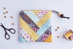 Quilted patchwork notions bag, buttons and retro scissors on white