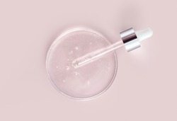 glass pipette serum gel in petri dish on a beige background