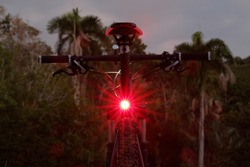 Close-up of illuminated bicycle tail light. Color red.