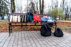 bags and backpacks lie on a Park bench.
