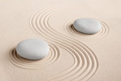 The yin and yang symbol. Balance. Good and evil. Stone garden for meditation. Japanese Zen concept. Buddhism and mindfulness. Concentration and concentration. Round stones on a sandy background. Philo