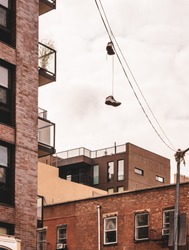 Pair of shoes hanging on wires over New York City buildings