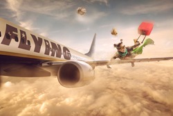 Woman flying in the wing of a moving plane, over clouds with luggage, low cost holiday concept. Photomanipulation