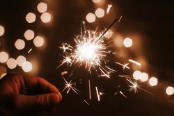 Man's hand holds sparklers, Happy New Year