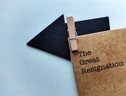 Black arrow clip with craft envelope with text written THE GREAT RESIGNATION, means the Big Quit, ongoing trend of employees voluntarily leaving their jobs in response to COVID-19