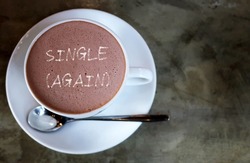 A cup of hot chocolate with text written SINGLE (AGAIN), concept of being single again after a breakup, got out of relationship or have lived the single life for a prolonged period of time