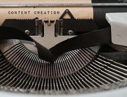 Old vintage classic typewriter with text typed CONTENT CREATION, concept of  information contribution, planning and creating useful and effective content to digital media for end-user or audience 
