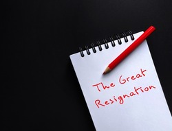 Red pencil, notebook on black copy space background with handwritten text THE GREAT RESIGNATION, concept of  the BIG QUIT, million employees voluntarily leave or resign from workforce after pandemic 