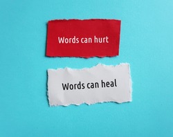 Torn paper on blue background with text Words can hurt , Words can heal - to remind language have power to harm or heal - word choice matters most so choose wisely