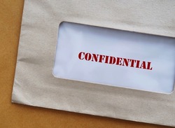 Office envelope with document typed CONFIDENTIAL, concept of data or information intended to be kept secret, secret or private, business or military top secret document