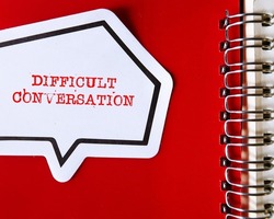 Speech sticker on red copy space background with text DIFFICULT CONVERSATION concept of request to have serious talk in sensible subjects at work or relationship, discuss personal issues conflict
