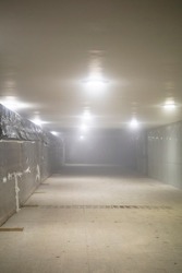 illuminated foggy underpass under construction on cold winter night