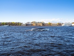Great Neva river with boat and view of Menshikov Palace edifice on Universitetskaya Embankment in Saint Petersburg city, Russia on sunny May day