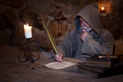Medieval man writes and studies letter 