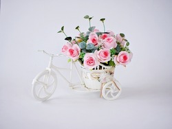 Artificial pink rose on bicycles on table isolated on white background bouquet bucket Bicycle with soft tone for festive background or wallpaper copy space for lettering Valentine's day romantic love 