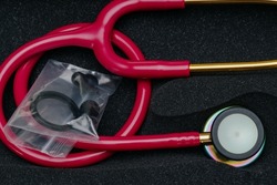 Medical stethoscope. Red medical stethoscope.The concept of healthcare.Stethoscope on a dark background