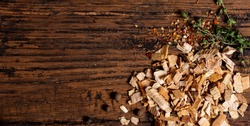Wood chips for smoking, spices and herb on an old wooden table top view. Free space for text.