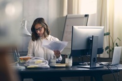 Beautiful young business woman sitting concentrated at her work in front of her office computer.